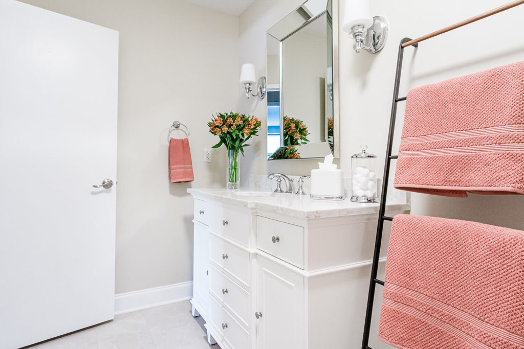 Guest bathroom renovation in white and greige with salmon pink accents