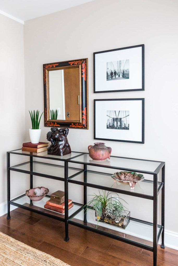 Glass console table with red accents, black and white Brooklyn photographs