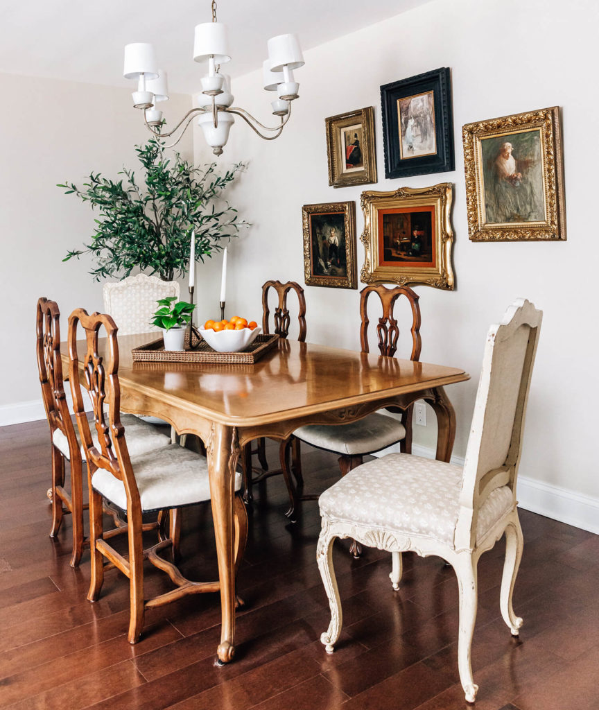 French inspired taupe formal dining room, gold frame antique art gallery, olive tree, slipper foot dining table and curvy, feminine chairs